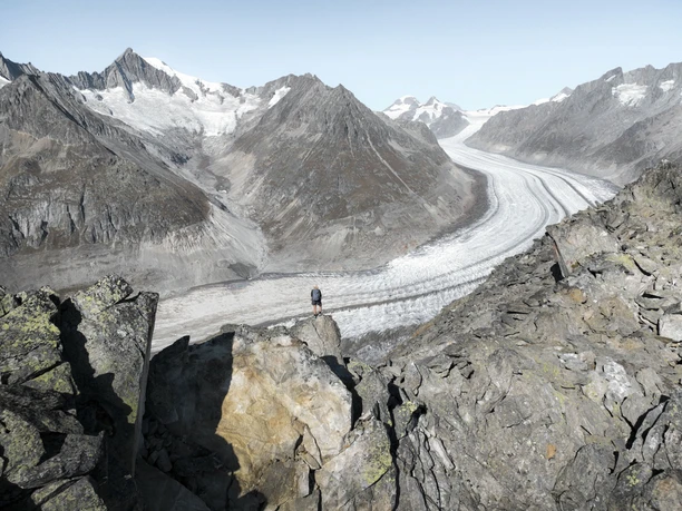 Weitblick über den Aletschgletscher Wanderer beim Stoneman Glaciara Hike auf felsigem Grat mit Blick auf den Grossen Aletschgletscher.