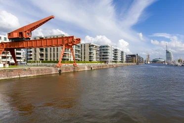 S8346 (c) Helmut Gross_Erlebnis Bremerhaven_WEB.jpg Roter Kiesverladekran am Alten Hafen in Bremerhaven vor modernen Gebäuden.