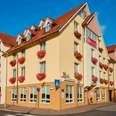 hotel-stadthoexter-hausansicht-c-marcusbrodt Außenansicht des dreistöckigen Hotels in Gelbtönen gestrichen mit Blumenkästen an den Fenstern