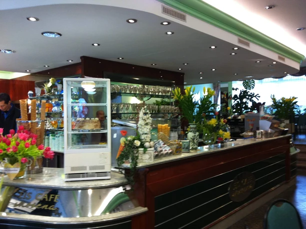 Eine elegante Theke in einem Eiscafé, dekoriert mit frischen Blumen und verschiedenen Eissorten.