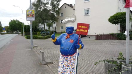 riedels-grilleck-aufsteller Lebensgroße blaue Kochfigur am Straßenrand