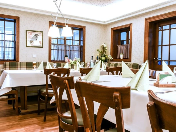 fs-raum Ein stilvoll eingerichtetes Restaurant mit gedeckten Tischen, gemütlichen Holzmöbeln und eleganter Beleuchtung.