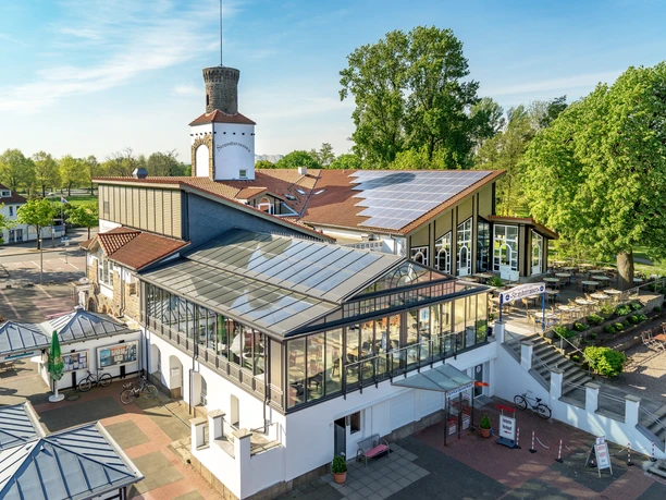 Conservatory of a large building complex, surrounded by trees, with bicycle racks in the foreground.