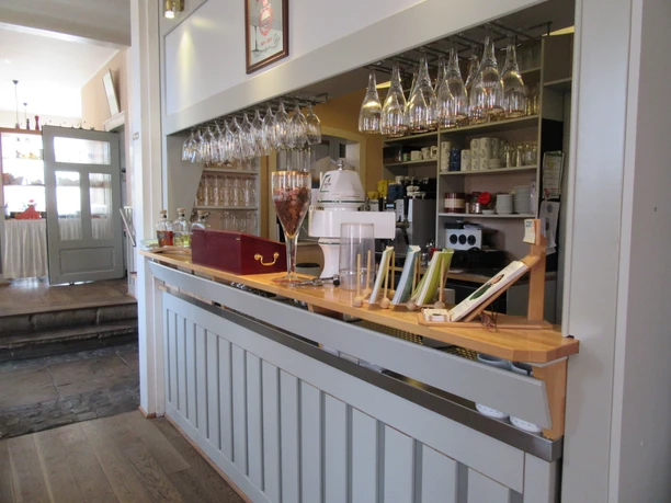 Inviting bar in the Hotel & Restaurant Alte Schule with stylish hanging wine glasses and modern furnishings.