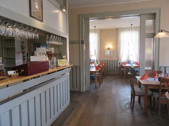 Hotel & Restaurant Alte Schule Einladender Restaurantbereich mit langen Holztischen, frischen Tischdecken und hellem Tageslicht.Inviting restaurant area with long wooden tables, fresh tablecloths and bright daylight.Indbydende restaurantområde med lange træborde, friske duge og stærkt dagslys.Uitnodigend restaurantgedeelte met lange houten tafels, frisse tafelkleden en helder daglicht.