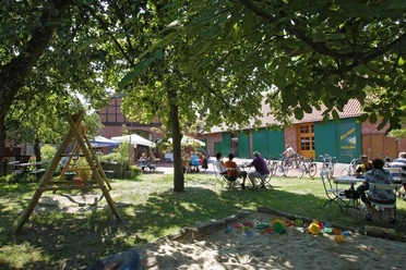 Café Honeck Café Honeck im Grünen mit Sitzgelegenheiten und Spielplatz, geeignet für Familienausflüge.