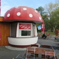 Ein kleines Café in Mardorf mit fliegenpilzförmigem Dach, umgeben von einladenden Sitzgelegenheiten.