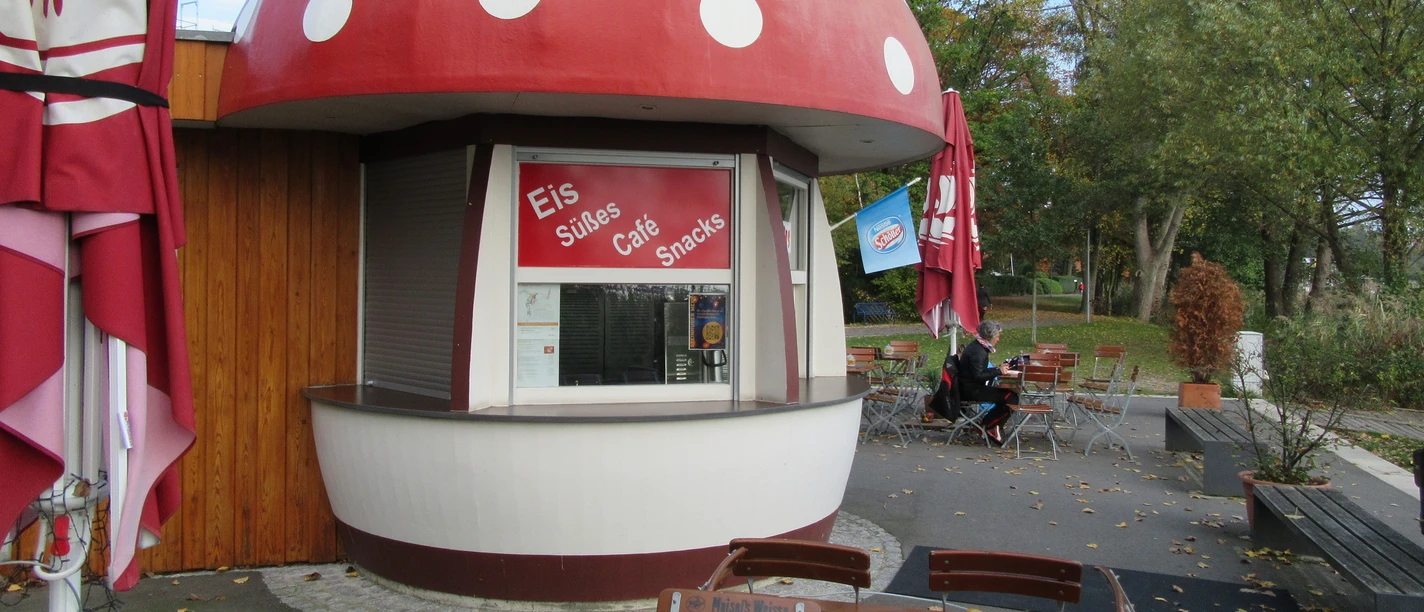 A small café in Mardorf with a mushroom-shaped roof surrounded by inviting seating.