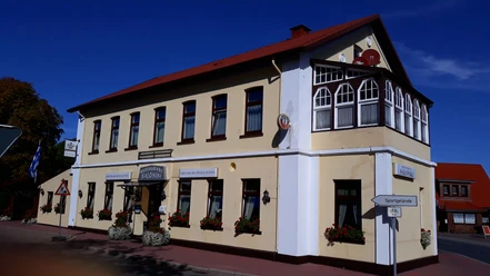 Restaurant Saloniki Das Restaurant Saloniki zeigt ein zweistöckiges Gebäude im traditionellen Stil mit weißen Wänden und roten Dachziegeln.