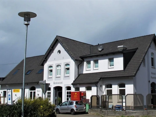 Gleis 3 im Bahnhof Augustfehn Der Bahnhof Augustfehn zeigt ein Gebäude mit weißer Fassade und schwarzem Schieferdach.