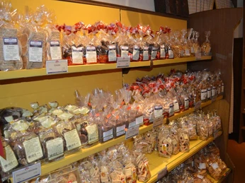 Keksgalerie im Schulze Ladencafé, Borgholzhausen Verschiedene Sorten von Keksen in durchsichtigen Tüten auf gelben Regalen in einem Ladencafé.