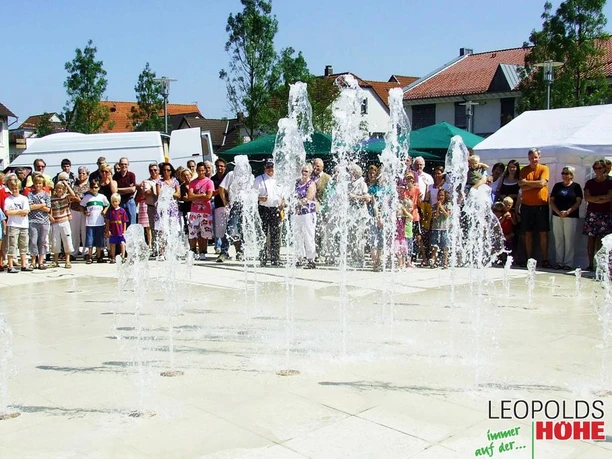 Marktplatz Leopoldshöhe Wasserspiel Wasserspiel auf dem Marktplatz Leopoldshöhe lockt Menschen aller Altersgruppen an, die es bestaunen.