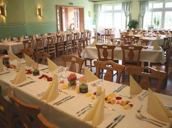 Lindensaal im Café zur Linde Ein heller Raum mit gedeckten Tischen, Stühlen und Dekoration, geeignet für Veranstaltungen und Feiern.