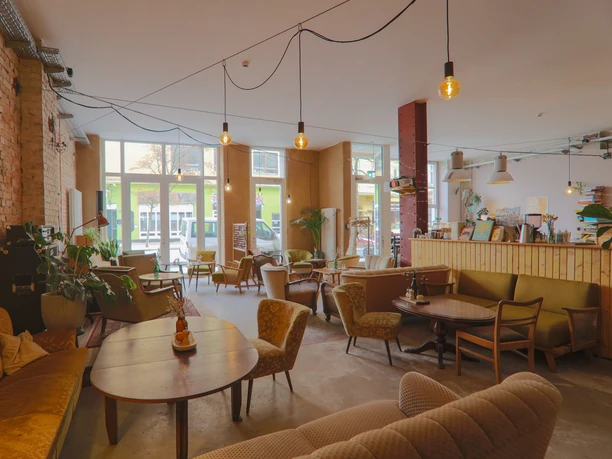 Findus 2 (c) LichtinSicht_WEB.jpg Heller Gastraum des Cafés Findus mit verschiedenen Vintage-Sitzmöbeln und Backsteinwand.