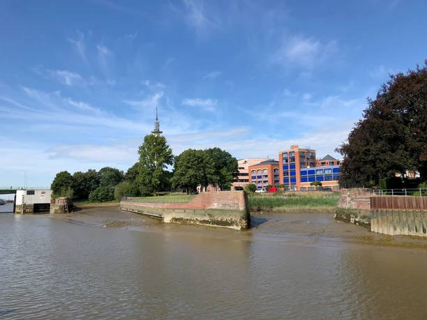 Wencke Dock in Bremerhaven (c) Mailin Knoke_Erlebnis Bremerhaven_WEB.jpg Das historische Wencke-Dock in Bremerhaven bei Ebbe, umgeben von Bäumen und modernen Gebäuden.