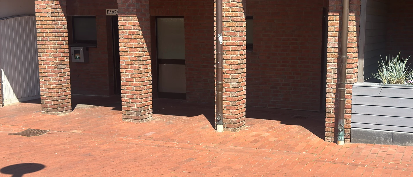 Toiletteneingang Neuer Winkel Drei Durchgänge vor dem Toilettengebäude am Ratskeller in Steinhude aus Pflastersteinen.