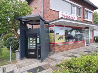 24/7 Eisautomat in Hambergen Ein überdachter Verkaufsautomat für Eis steht vor dem Klinkerbau der Fleischerei Thamm.