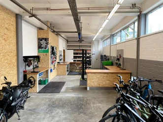 2Rad FeDe Heiligenhaus Helle Werkstatt in Heiligenhaus mit Fahrrädern, Werkbänken, Werkzeugen und Motorrad.
