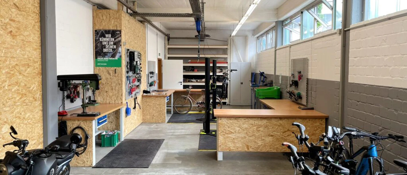2Rad FeDe Heiligenhaus Helle Werkstatt in Heiligenhaus mit Fahrrädern, Werkbänken, Werkzeugen und Motorrad.