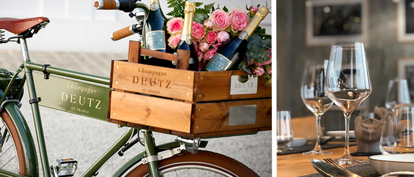Champagner Deutz x Stivie Cuisine Fahrrad mit Champagner und Rosen neben elegant gedecktem Tisch mit Gläsern.