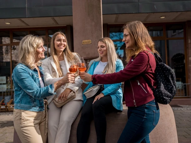 Gruppe beim Anstoßen vorm Brunnen in der Kapellenstraße