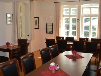 Gastraum im Restaurant Burg Ravensberg, Borgholzhausen Restaurant-Gastraum mit Holztischen und Stühlen, große Fenster lassen viel Tageslicht herein.