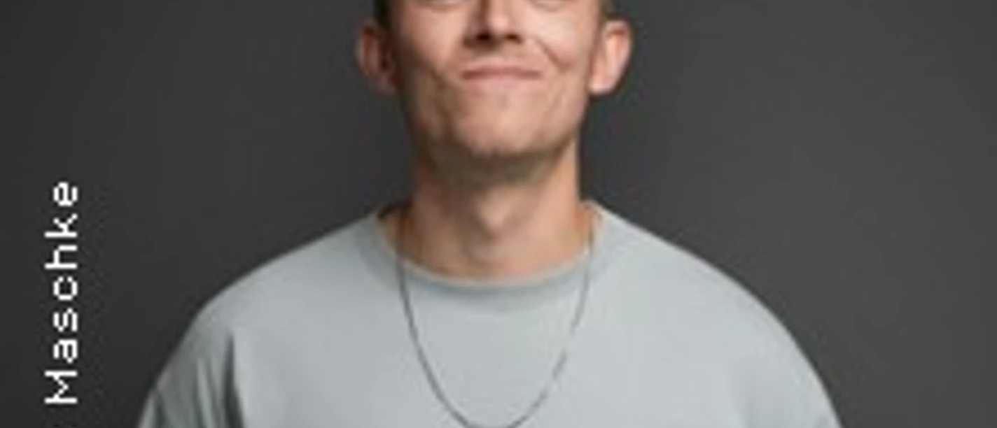 Junger Mann in hellem Shirt vor dunklem Hintergrund mit entspanntem Gesichtsausdruck.