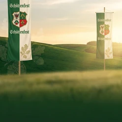 Schützenfeste Zwei grün-weiße Fahnen mit Wappen zum Schützenfest vor hügeliger Landschaft bei Sonnenlicht