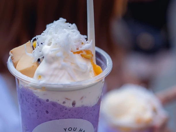 Ube Fiesta Becher mit violettem Halo-Halo-Dessert, garniert mit Sahne, Eisstücken und Kokosraspeln
