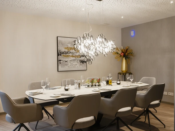 Modern eingerichteter Restaurantbereich im Claras Restaurant des Schönes Leben Wolfsburg mit stilvoll gedecktem Tisch für mehrere Personen.