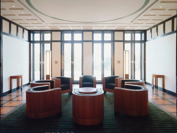 O.M. Ungers, Residenz des Deutschen Botschafters, Washington, D.C. 1987–1995 Heller Raum mit schwarzen Fenstern und sechs runden Holzsesseln in symmetrischer Anordnung