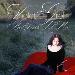 Frau sitzt auf rotem Stoff im Gras, darüber stilisierte Schrift mit Albumtitel