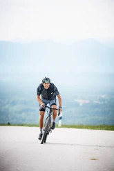 2-Seen-Tour Radfahrer auf Asphalt vor hellen Bergen und weiter Sicht, Bewegung und Naturgefühl.