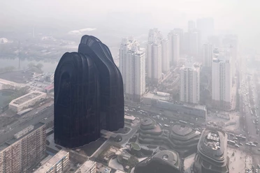 Beijing 79 Dark, curved skyscrapers rise up in a foggy urban landscape with dense traffic