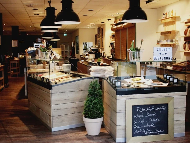 schmeckwerk-k-che Tresen mit Auslagen in Holzoptik im Gastraum