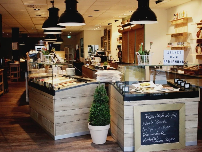 schmeckwerk-k-che Tresen mit Auslagen in Holzoptik im Gastraum
