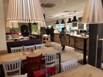 schmeckwerk-gastraum Gastraum mit Holztischen, roten und weißen Stühlen