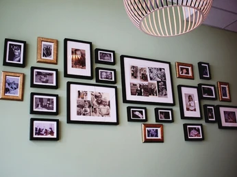 schmeckwerk-familie Wand mit vielen historischen gerahmten Aufnahmen