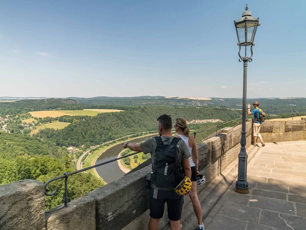 Zwei Radfahrer blicken von der Festung Königstein hinunter zur Elbe