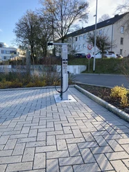 Fahrrad-Reparaturstation Parkplatz Sporthalle Adlerstraße Fahrrad-Reparaturstation mit Werkzeugen und Luftpumpe auf gepflastertem Untergrund.