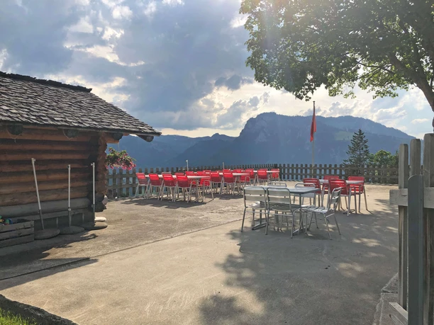 Terrace Gasthaus Gsässweid Concreted terrace with red tables and garden chairs