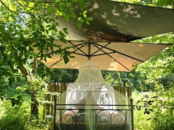 Schlafen unter Sternen Sie sehen das Himmelbett, was im Garten unter Bäumen steht.