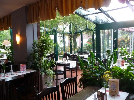 trattoria_drinne Ein heller, freundlicher Gastraum mit vielen Pflanzen. Große Fenster lassen viel Licht herein.