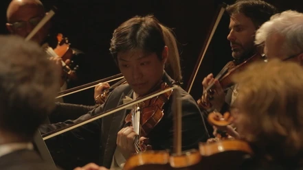 VA für Stadjubiläum.jpg Nahaufnahme eines Geigers, der mit seinem Orchester bei einer Jubiläumsveranstaltung spielt.