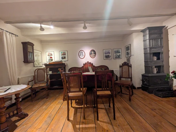 Heimatmuseum, Trauzimmer, Greene Historisches Trauzimmer im Heimatmuseum Greene mit antiken Möbeln und einem gusseisernen Ofen.