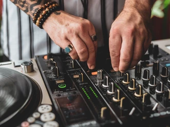 DJ.jpg Nahaufnahme vom DJ Mischboard. Zwei Hände drehen an den Knöpfen.