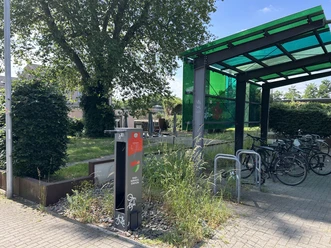 Fahrrad-Reparaturstation Bahnhof Hilden / Radabstellanlage Grau-rote Fahrrad-Reparaturstation und überdachte Radabstellanlage mit Fahrrädern am Bahnhof Hilden.