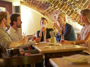 Früh am Dom Eine Gruppe von Menschen sitzt im Gewölbekeller des Brauhauses.A group of people are sitting in the vaulted cellar of the brewery.