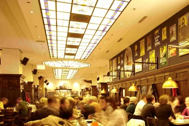 Gaffel am Dom Innenansicht von gut besuchtem Brauhaus in warmen Licht geflutet.