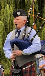 Bagpiper Harry in schottischer Tracht spielt auf seinem Dudelsack.